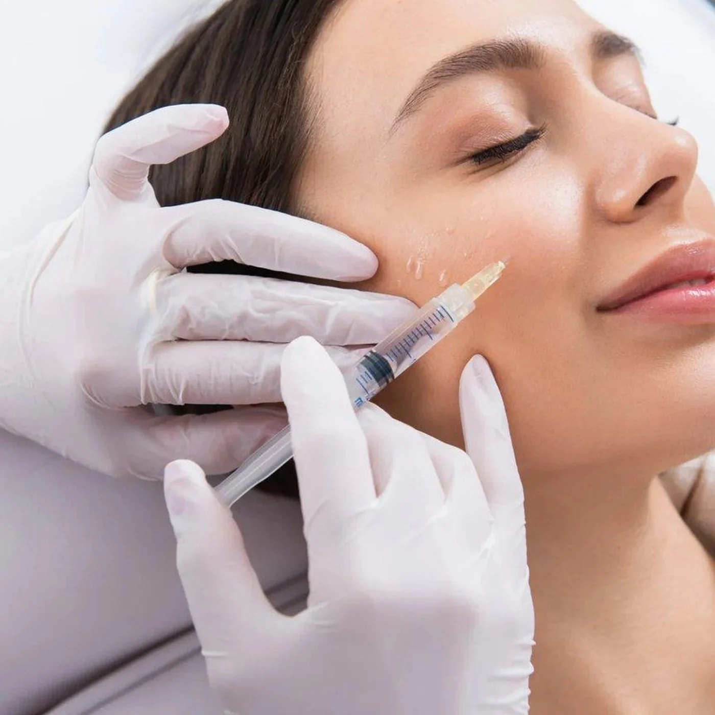 Dermal filler treatment being administered to a client's cheek